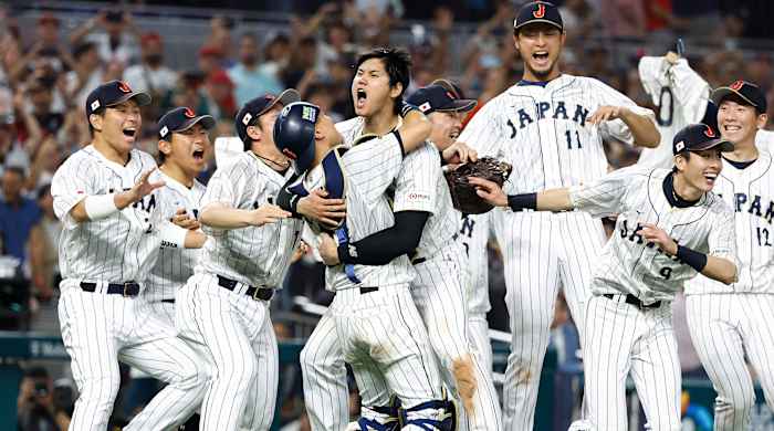 Team Japan crowds around the mound to celebrate World Baseball Classic win
